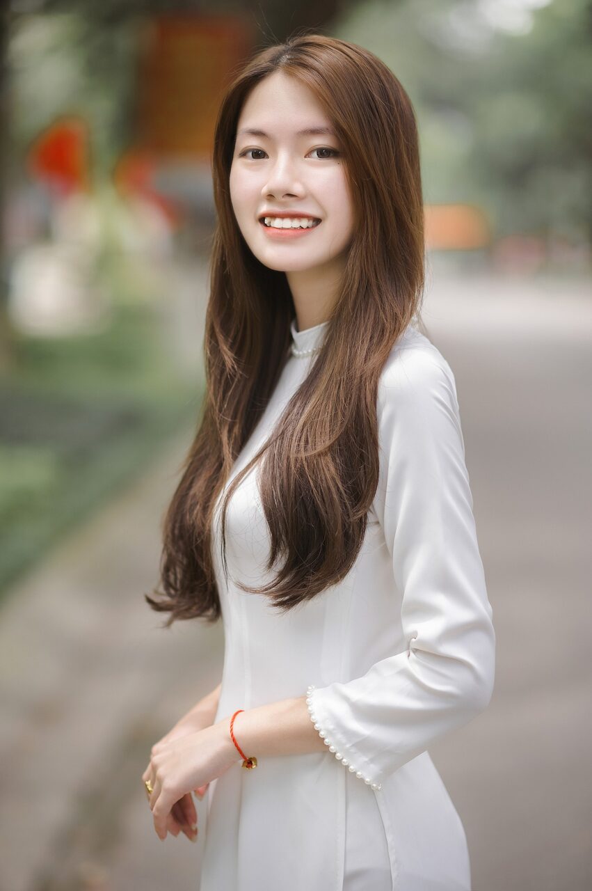 沿着落满花瓣的小路走来，裙摆被风轻轻带起。